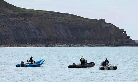 People stand on boats in Wimereux, near Calais, after migrants died in an attempt to cross the English Channel (Reuters)
