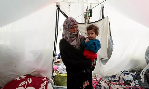 Displaced Palestinian woman holds her daughter after she was checked for malnutrition, at their tent in Rafah, in the southern Gaza Strip (Reuters)