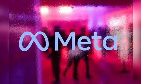 People walk behind a Meta Platform logo during a Conference in Mumbai (Reuters)