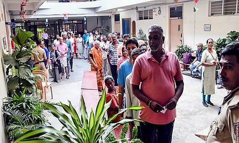 Voters stand in a queue to cast their votes (ANI)