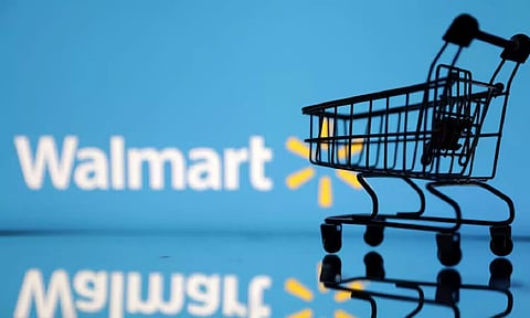 Shopping trolley is seen in front of Walmart logo (Reuters)