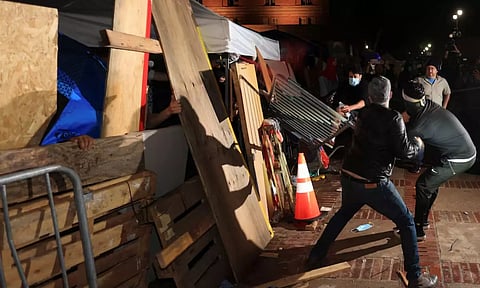 Counter-protesters strike a barricade at a pro-Palestinian encampment on the University of California (Reuters)