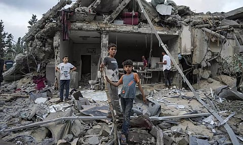 Palestinians look at the destruction after an Israeli airstrike in Deir al Balah,Gaza Strip (AP)