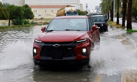Cars drive through flooded road after rainstorm in Dubai (Reuters)