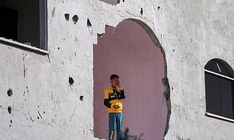 A child stands inside a building, damaged in an Israeli strike in Rafah (Reuters)