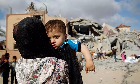 A Palestinian child looks on at the site of an Israeli strike on a house in Rafah (Reuters)