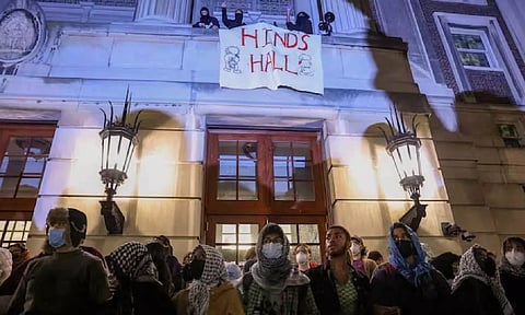 Protesters link arms outside Hamilton Hall barricading students inside the building at Columbia University (Reuters)