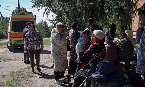 Residents from Vovchansk and nearby villages wait for buses amid an evacuation to Kharkiv due to Russian shelling (Reuters)