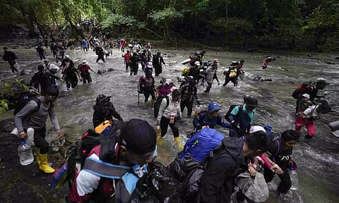 Migrants cross a river during their journey through Darien Gap from Colombia to Panama (AP)