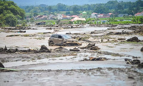 A damaged car is seen in an area area affected by heavy rain brought flash floods and landslides in Agam (Reuters)