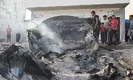 Palestinians inspect boats damaged in Israeli fire (Reuters)