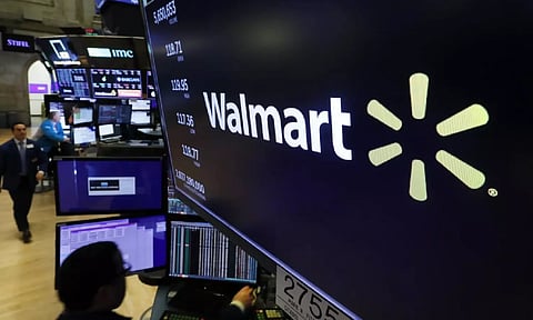 The logo for Walmart appears above a trading post on the floor of the New York (AP)