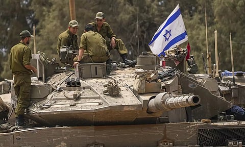 Israeli soldiers work on a tank near the Israeli-Gaza border, in southern Israel (AP)