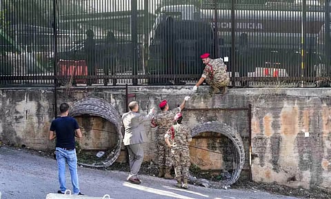 
Lebanese Army investigators inspect bullet holes and collect forensic evidence next to the entrance of U.S. Embassy in Aukar (Photo/AP)