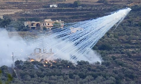 A shell that appears to be white phosphorus from Israeli artillery explodes over a house in al-Bustan, a Lebanese village along the border with Israel, on Oct. 15, 2023 (AP)