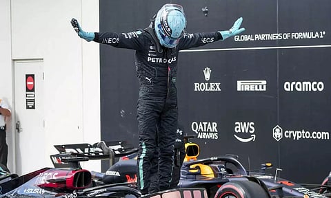 George Russell celebrates after taking pole position (AP)