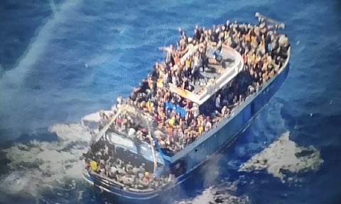 People sit on a battered fishing boat that later capsized and sank off southern Greece (AP)