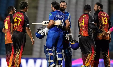 Afghanistan's batsmen Gulbadin Naib and Mohammad Nabi embrace after defeating Papua New Guinea (PTI)