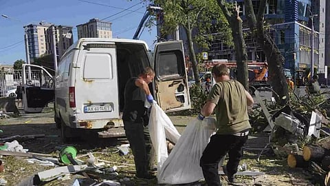 Municipal workers carry a dead body killed after an apartment building was hit by Russian air bomb killing at least three and injuring 23, in Kharkiv, Ukraine (Photo/AP)