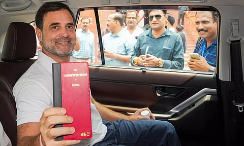 Congress member Rahul Gandhi shows a book of Constitution of India at the Parliament House complex (PTI)