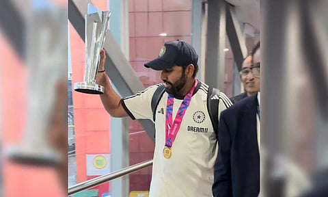 Rohit Sharma holding the trophy at the Delhi Airport (Photo: X)