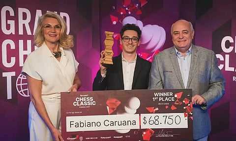 Fabiano Caruana poses with winner's trophy