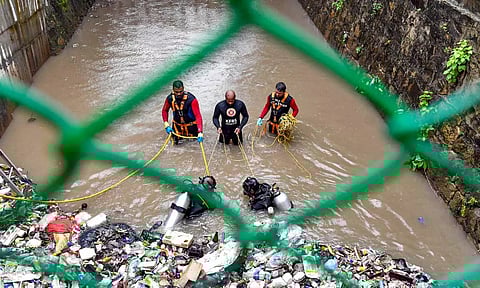 Scuba diving team of the fire department conducts a search and rescue operation after a sanitation worker went missing inside the Amayizhanjan canal (PTI)