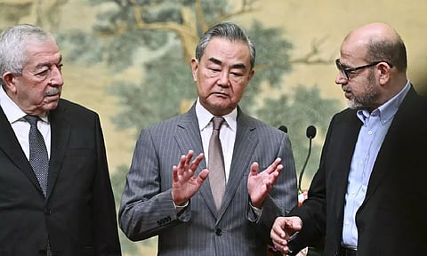 China's Foreign Minister Wang Yi, center, hosts an event for Mahmoud al- Aloul, left, vice chairman of Fatah, and Mussa Abu Marzuk, a senior member of Hamas, to meet at the Diaoyutai State Guesthouse in Beijing,&nbsp;