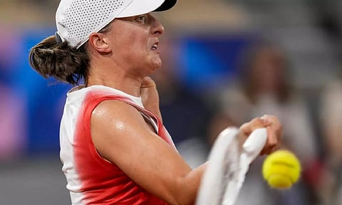 Iga Swiatek of Poland returns the ball against Irina-Camelia Begu of Romani during a women's singles tennis competition (AP)