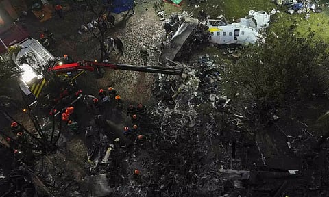 Firefighters and rescue workers work in the debris at the site where an airplane with 61 people on board crashed (AP)