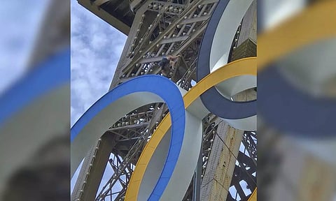 A man is seen climbing the Eiffel Tower (AP)