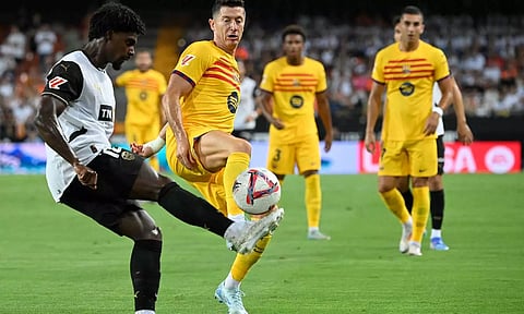 Valencia defender Thierry Correia and Barcelona forward Robert Lewandowski vie for the ball&nbsp;