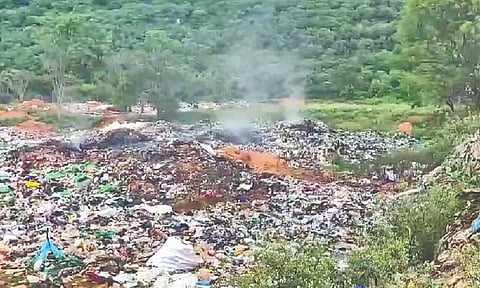Smoke billows from a garbage dump put on fire by miscreants, resulting in air pollution and breathing issues for residents