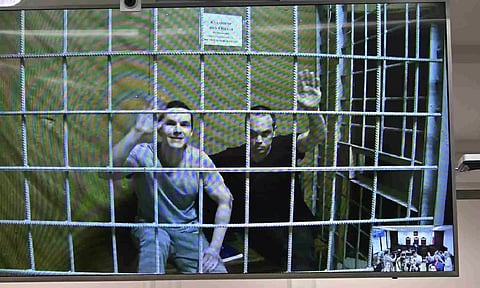 Alexei Liptser, left, and Vadim Kobzev, lawyers for Alexei Navalny, sit behind bars shown in a video link provided by the Russian Federal Penitentiary Service (AP)
