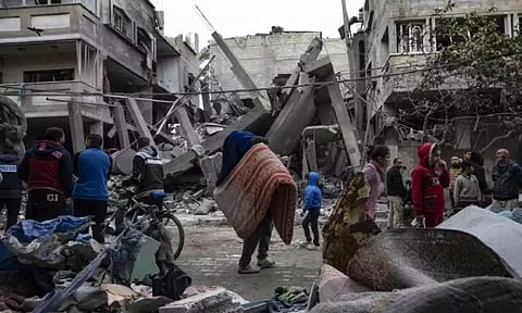 Palestinians inspect the damage of residential buildings after an Israeli airstrike
