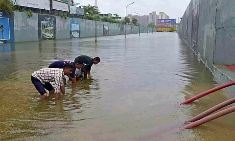 Rescue workers from the Gandhinagar Fire and Emergency Services effort to remove water from a flooded underpass after heavy rains on the outskirts of Ahmedabad | AFP