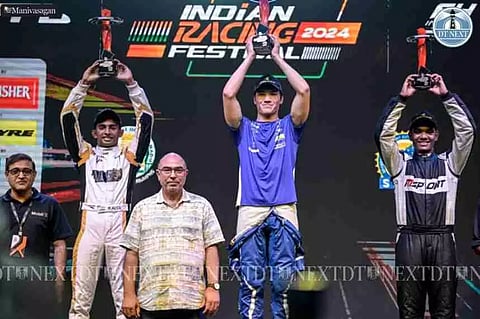 Formula 4 (F4) night street race winners Hugh Barter (C), Ruhaan Alva (L), and Abhay Mohan (R) strike a pose with their trophies. (Photo | Manivasagan)