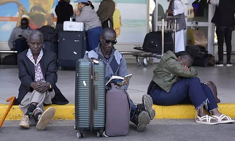 Stranded passengers wait for their delayed flights out of JKIA airport after flights were grounded following workers' protesting a planned deal between the government and a foreign investor (AP)