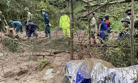 Rescue workers clear mud and debris brough down by a flood in Lang Nu hamlet in Lao Cai province, Vietnam Tuesday (AP)