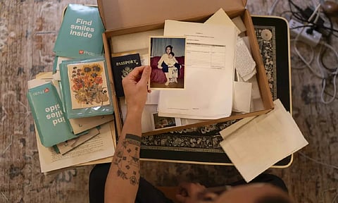 Robert Calabretta holds a picture of his biological mother and brother while sifting through family mementos at his apartment (AP)