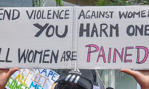 A placard denouncing violence against women being held at a protest march (PTI)