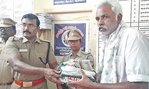 Police handing over the money to Kamaraj on Tuesday