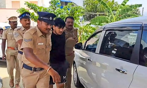 Police personnel take a member of a gang suspected to have been involved in ATM heist in Kerala's Thrissur (Photo: PTI)