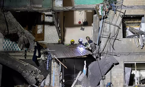 Rescue workers clear the rubble inside a building damaged by a Russian airstrike in Kharkiv (AP)