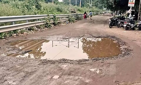 Water stagnates on the damaged road near Villivakkam railway station