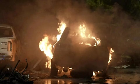 A vehicle is seen on fire at the site of an explosion that caused and destroyed vehicles at outside the Karachi airport, Pakistan (AP)