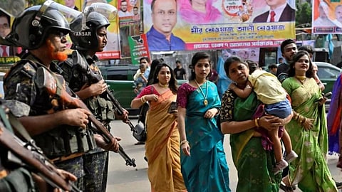 Security force personnel stand guard to Hindu devotees on Durga Pooja (Reuters)