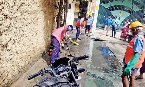 Cleanliness workers clear overflowing drainage on Arian Lane in Vepery