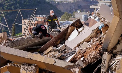 Rescue workers search for victims hit in an Israeli airstrike (AP)