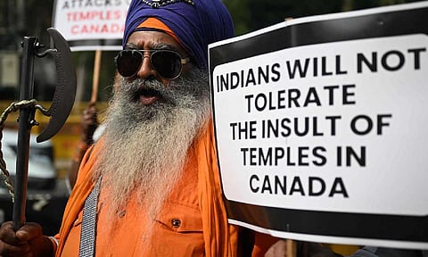 A Nihang Sikh warrior holds a placard as he takes part in a protest near the Canadian embassy in New Delhi against the recent attack on a Hindu temple in the city of Brampton (AFP)